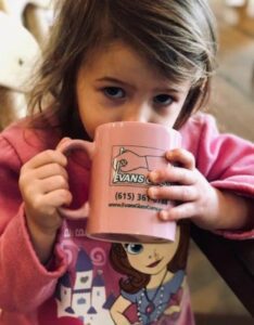 Little girl drinkin Hot Chocolate from an Evans Glass Cup